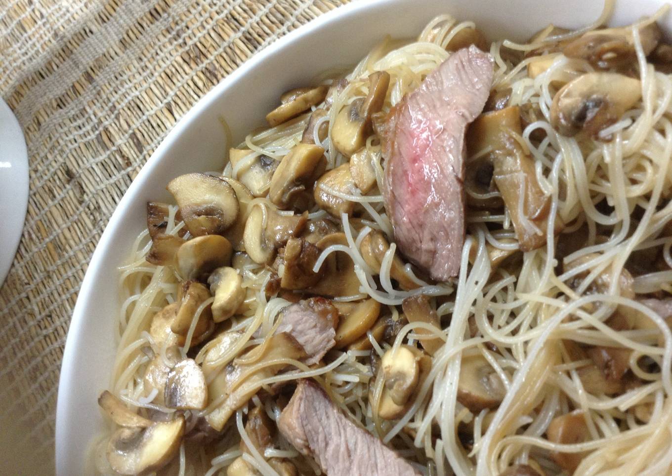 blushing beef slices and mushrooms in rice noodles