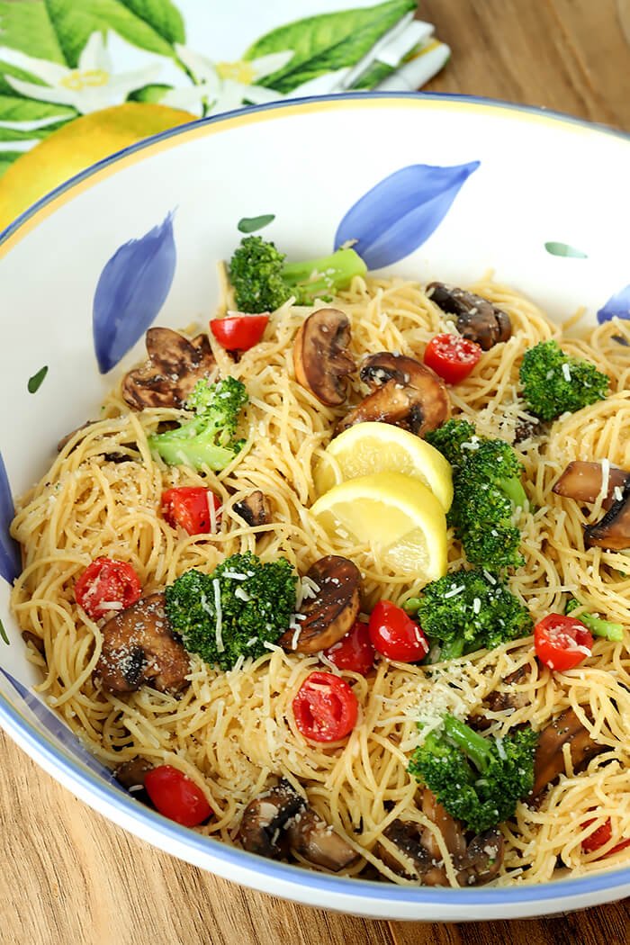 Pasta with Broccoli, Tomato, Mushrooms, and Parmesan Cheese in a Large White, Blue and Yellow Pasta Bowl