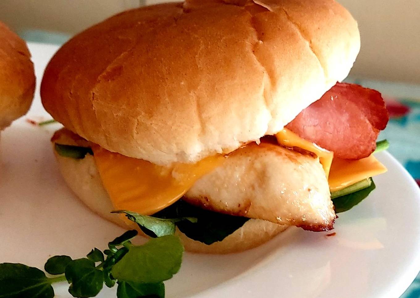 a plain chicken bacon cheese burger with watercress