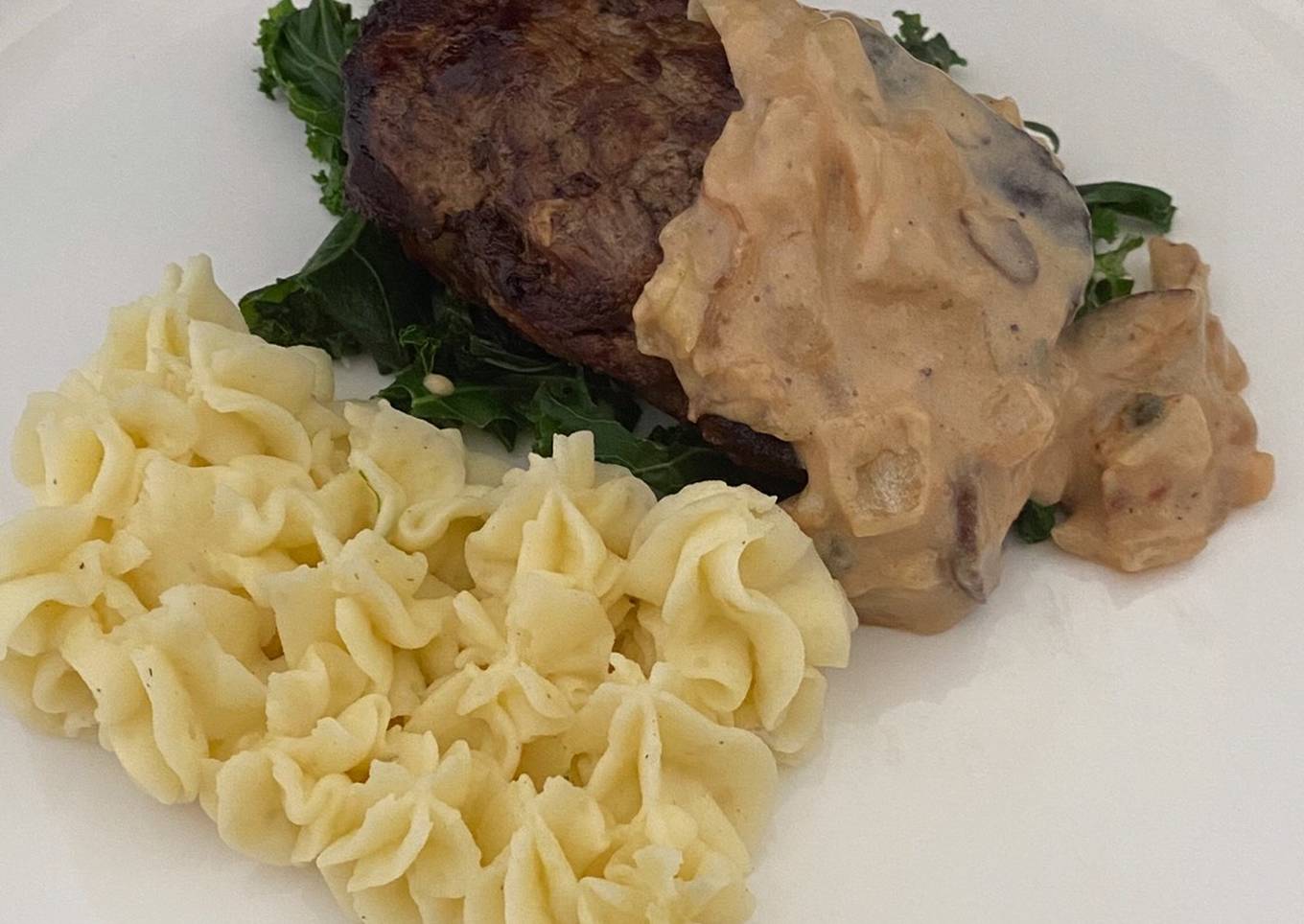 filet mignon with creamy mashed potato and kale served with a peppercorn sauce
